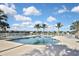 Beautiful community pool surrounded by swaying palm trees and comfortable lounge chairs under a brilliant sky at 28059 Arrowhead Cir, Punta Gorda, FL 33982