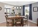 Cozy dining room with a wooden table set for four, modern lighting, and view to the kitchen at 28059 Arrowhead Cir, Punta Gorda, FL 33982