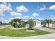 Charming single-Gathering home featuring a lush green lawn and meticulously landscaped front yard with palm trees at 28059 Arrowhead Cir, Punta Gorda, FL 33982