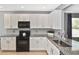 Kitchen showcases white cabinets, granite countertops, stainless steel sink and backsplash at 28059 Arrowhead Cir, Punta Gorda, FL 33982