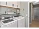 Functional laundry room with overhead storage, modern appliances, and convenient access to additional spaces at 28059 Arrowhead Cir, Punta Gorda, FL 33982