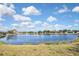 Calm pond framed by a grassy foreground, offering a relaxing natural view, reflecting the beautiful clear blue sky above at 28059 Arrowhead Cir, Punta Gorda, FL 33982