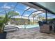 Enclosed pool area with lounge chairs, seating, and a view of the lush landscaping, perfect for relaxation at 28059 Arrowhead Cir, Punta Gorda, FL 33982