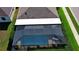 Aerial view of screen-enclosed pool with outdoor seating in backyard, surrounded by lush greenery at 28059 Arrowhead Cir, Punta Gorda, FL 33982