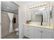 Bathroom featuring a tile shower, white vanity with decorative mirror and countertop with decorative plant at 2903 Pope St, North Port, FL 34287