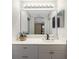 Bright bathroom featuring a white vanity with decorative mirror and countertop with decorative plant at 2903 Pope St, North Port, FL 34287