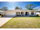 Charming single-story home with attached garage and a cozy front porch with decorative columns and green lawn at 2903 Pope St, North Port, FL 34287