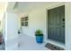 Inviting front entry with a gray door, modern door hardware, potted plants, a welcome mat, and sidelight window at 2903 Pope St, North Port, FL 34287