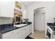Bright kitchen featuring white cabinets, dark counters, and a double basin sink at 2903 Pope St, North Port, FL 34287