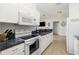 Well-lit kitchen featuring white cabinets, granite countertops, and stainless steel appliances at 2903 Pope St, North Port, FL 34287
