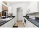 Well-lit kitchen featuring white cabinetry and dark countertops at 2903 Pope St, North Port, FL 34287