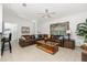 Spacious living area with a large sectional sofa, ceiling fan, and neutral-toned tile flooring at 2903 Pope St, North Port, FL 34287