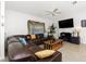 Inviting living room featuring comfortable seating, tile flooring, ceiling fan, and a modern entertainment center at 2903 Pope St, North Port, FL 34287