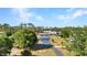 Aerial view of the property featuring a driveway to a garage with blue doors surrounded by green trees at 29324 Leah Rd, Punta Gorda, FL 33982