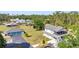 An aerial view of the home with a blue garage and a screened deck surrounded by lush greenery at 29324 Leah Rd, Punta Gorda, FL 33982