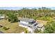 Aerial view of home featuring a screened porch, tiki bar, stairs, and nearby swimming pool surrounded by lush trees at 29324 Leah Rd, Punta Gorda, FL 33982