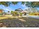 Well maintained backyard featuring a covered tiki bar, pool, and screened porch surrounded by green trees at 29324 Leah Rd, Punta Gorda, FL 33982