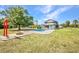 Expansive backyard featuring a refreshing pool, Tiki hut, fire pit and mature trees at 29324 Leah Rd, Punta Gorda, FL 33982