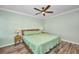 Bright bedroom with a sage green bedspread, and simple wood bedside tables and lamps at 29324 Leah Rd, Punta Gorda, FL 33982