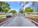 Gated entrance with white fencing and well-maintained landscaping, adding curb appeal and security to the property at 29324 Leah Rd, Punta Gorda, FL 33982