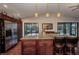 Open kitchen boasts granite counters, stainless appliances, dark wood cabinets, and views to screened porch at 29324 Leah Rd, Punta Gorda, FL 33982