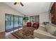 Comfortable living room boasts sliding door access to porch, patterned rug, plush seating, and a large window at 29324 Leah Rd, Punta Gorda, FL 33982