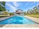 Refreshing pool with a tiki hut and lounging area, creating a relaxing oasis for outdoor enjoyment and recreation at 29324 Leah Rd, Punta Gorda, FL 33982