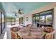 Screened porch features an outdoor dining table, ceiling fans, and serene views at 29324 Leah Rd, Punta Gorda, FL 33982