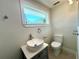 Updated bathroom with a vessel sink, modern toilet, and a large window at 352 Oak St, Englewood, FL 34223