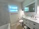 Well-lit bathroom with a modern vanity, large mirror, and a combination shower/tub at 352 Oak St, Englewood, FL 34223