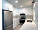 Bright kitchen featuring white cabinets, stainless steel appliances, and quartz countertops at 352 Oak St, Englewood, FL 34223