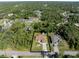 Aerial view of a home with a large lot surrounded by lush greenery and other homes at 3621 Jade St, North Port, FL 34288