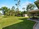 Backyard with a well-maintained lawn, mature trees, a shed, and a screened lanai at 3621 Jade St, North Port, FL 34288