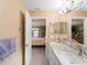 Bathroom featuring a double sink vanity and view to bedroom, with lots of counter space at 3621 Jade St, North Port, FL 34288