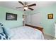 Light bedroom with a ceiling fan, closet with sliding doors, and simple decorations at 3621 Jade St, North Port, FL 34288