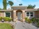 Welcoming front entrance showcasing a light-colored door, stucco facade, and colorful landscaping at 3621 Jade St, North Port, FL 34288