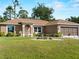 Charming single-story home features a manicured lawn and landscaping in front of the home at 3621 Jade St, North Port, FL 34288