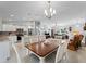 Open-concept kitchen featuring white cabinets, stainless steel appliances, and an island at 3621 Jade St, North Port, FL 34288