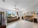 Spacious living room with two sofas, a ceiling fan, and a large window at 3621 Jade St, North Port, FL 34288