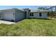 Charming single-story home featuring a well-maintained lawn and an attached two-car garage at 369 Biltmore St, Port Charlotte, FL 33953