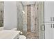 Well lit bathroom featuring white cabinets and a glass shower with decorative stone and tile at 3712 Carmichael Dr, Punta Gorda, FL 33950