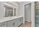 Bathroom featuring double sinks, gray cabinets, stone tile shower, and tile flooring at 3712 Carmichael Dr, Punta Gorda, FL 33950