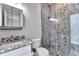 Bathroom with granite vanity, and a shower with glass door and river rock floor at 3712 Carmichael Dr, Punta Gorda, FL 33950