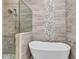 Bathroom featuring a frameless glass shower and a modern soaking tub with stone tile surround at 3712 Carmichael Dr, Punta Gorda, FL 33950