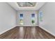 Bright bedroom with tray ceiling, ceiling fan, and wood-look tile flooring, illuminated by three windows at 3712 Carmichael Dr, Punta Gorda, FL 33950