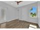 Bright bedroom with wood-look tile flooring, ceiling fan, and natural light at 3712 Carmichael Dr, Punta Gorda, FL 33950