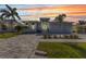 Beautiful single story home with lush landscaping, brick driveway, and sunset sky at 3712 Carmichael Dr, Punta Gorda, FL 33950