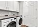 Bright laundry room includes white cabinetry, a granite countertop, and stainless steel washer and dryer at 3712 Carmichael Dr, Punta Gorda, FL 33950