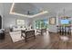 Open-concept living room with modern furniture, access to the pool and a nearby dining area with views of the golf course at 3712 Carmichael Dr, Punta Gorda, FL 33950