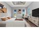 Bright main bedroom featuring a decorative tray ceiling, hardwood floors, three windows and neutral-toned contemporary decor at 3712 Carmichael Dr, Punta Gorda, FL 33950